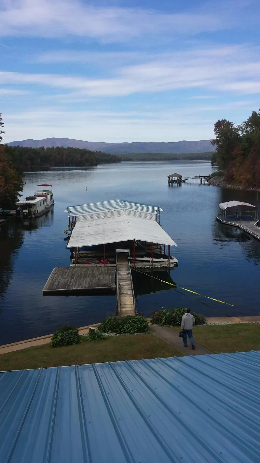 View across a lake from a newly installed blue metal roof in Jamestown